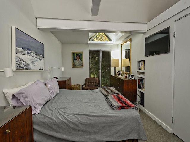 carpeted bedroom featuring baseboards and beam ceiling