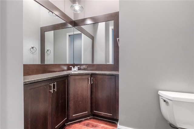 bathroom featuring hardwood / wood-style flooring, toilet, and vanity