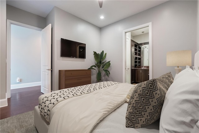 bedroom featuring connected bathroom, ceiling fan, dark hardwood / wood-style floors, and a walk in closet