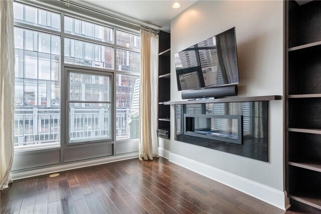 unfurnished living room with dark wood-type flooring and a fireplace