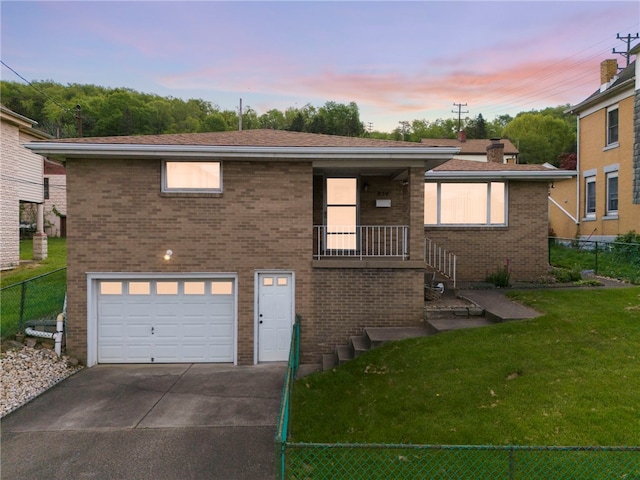 view of front of property with a garage and a lawn