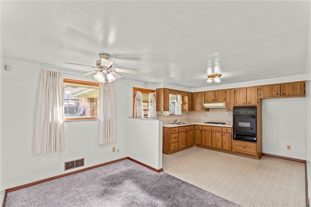 kitchen featuring ceiling fan, backsplash, stainless steel gas cooktop, sink, and double oven