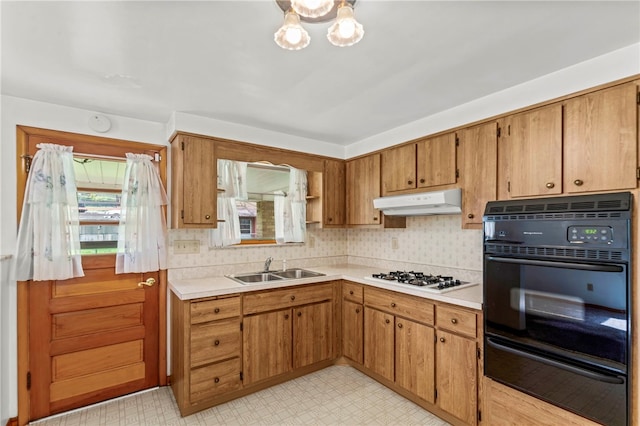 kitchen featuring white gas stovetop, sink, black double oven, and light tile floors