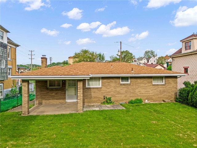 rear view of property with a lawn and a patio