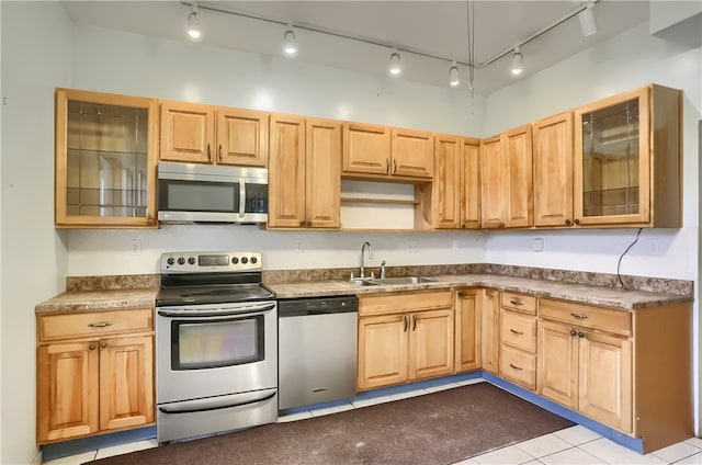 kitchen with light brown cabinets, track lighting, stainless steel appliances, sink, and light tile patterned flooring