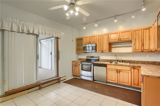 kitchen featuring a baseboard heating unit, sink, light tile patterned floors, appliances with stainless steel finishes, and ceiling fan