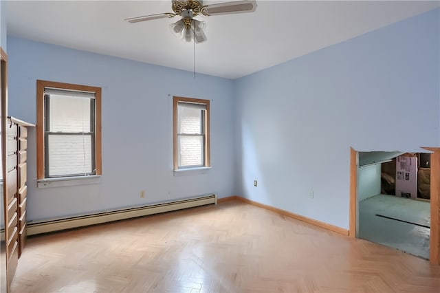 unfurnished room with a baseboard heating unit, light parquet floors, and ceiling fan