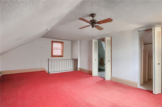 bonus room featuring carpet, vaulted ceiling, a textured ceiling, and ceiling fan