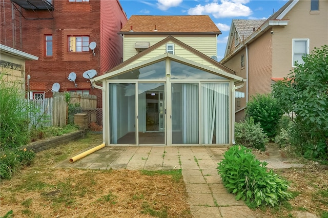 rear view of house featuring a patio and a sunroom