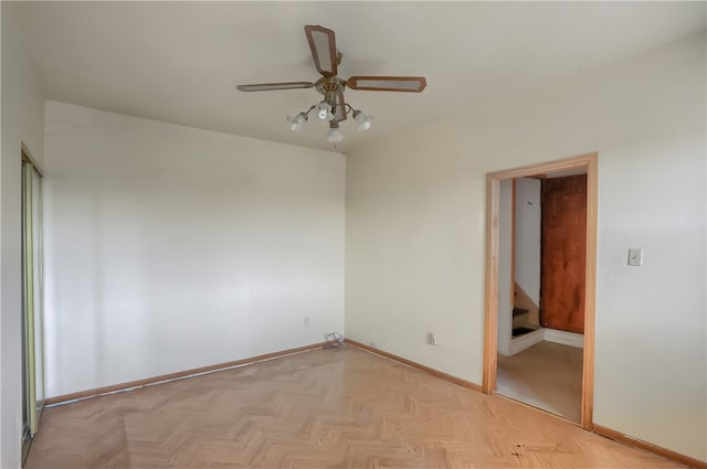 empty room with ceiling fan and light parquet flooring