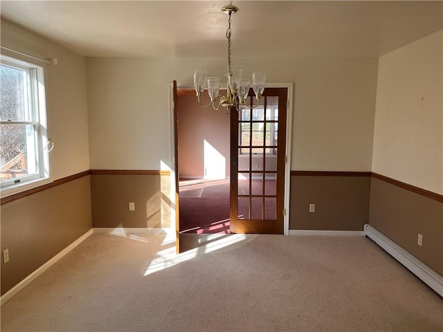 unfurnished dining area with carpet flooring, a notable chandelier, and a baseboard heating unit