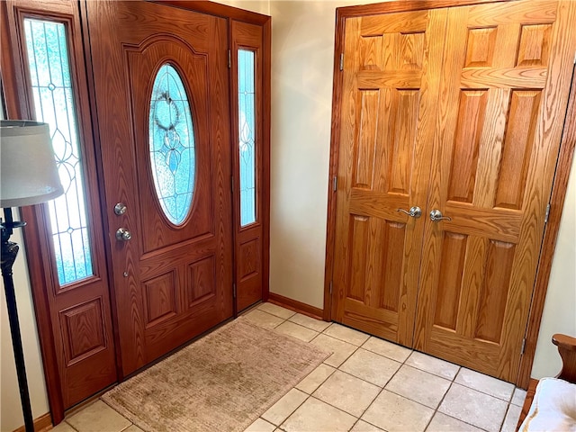 entryway featuring baseboards and light tile patterned flooring