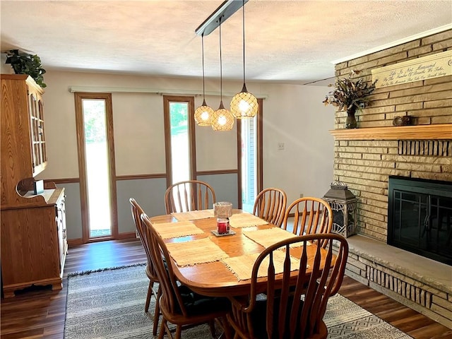 dining room with dark hardwood / wood-style floors, a fireplace, and a textured ceiling