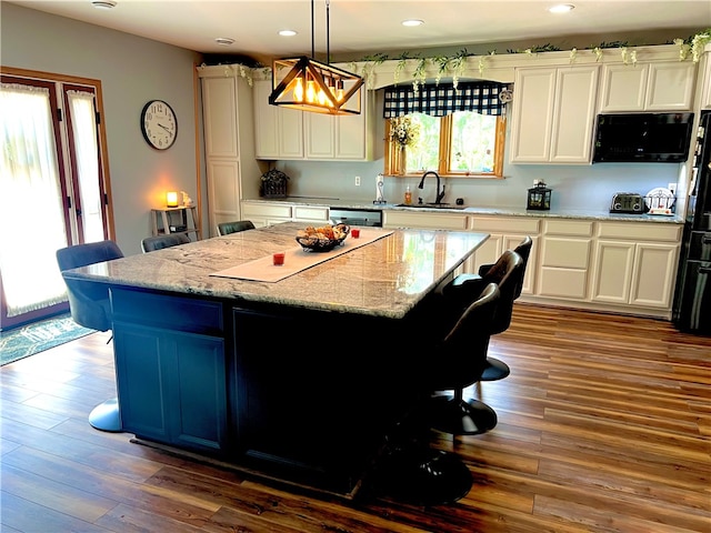 kitchen featuring dark wood-type flooring, a center island, and hanging light fixtures