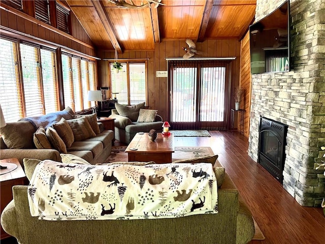 living room with lofted ceiling with beams, wood walls, dark hardwood / wood-style floors, and a wealth of natural light