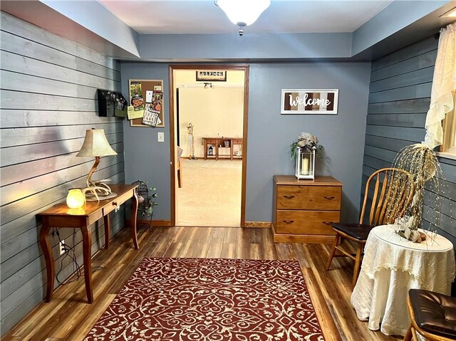 living area with wood-type flooring and wooden walls