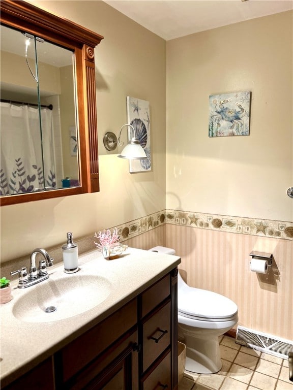 bathroom featuring tile patterned flooring, vanity, and toilet