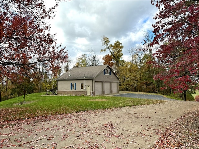 view of home's exterior featuring a lawn, a garage, and an outbuilding