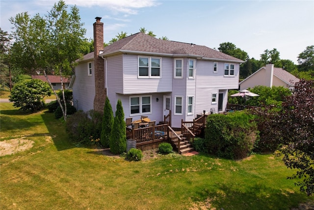 rear view of house featuring a deck and a yard