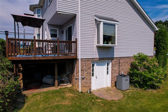 back of property featuring central AC unit, a wooden deck, and a yard