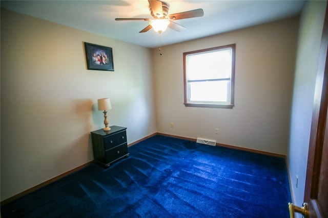 empty room featuring dark carpet and ceiling fan