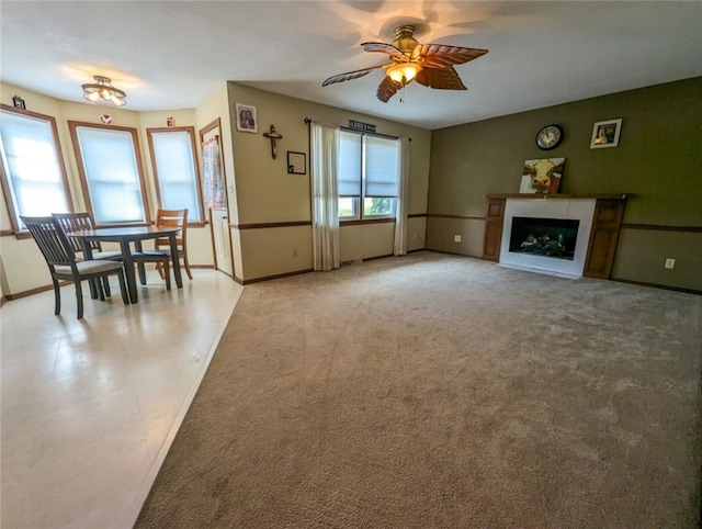 unfurnished living room featuring ceiling fan and carpet floors