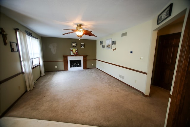 unfurnished living room featuring carpet and ceiling fan