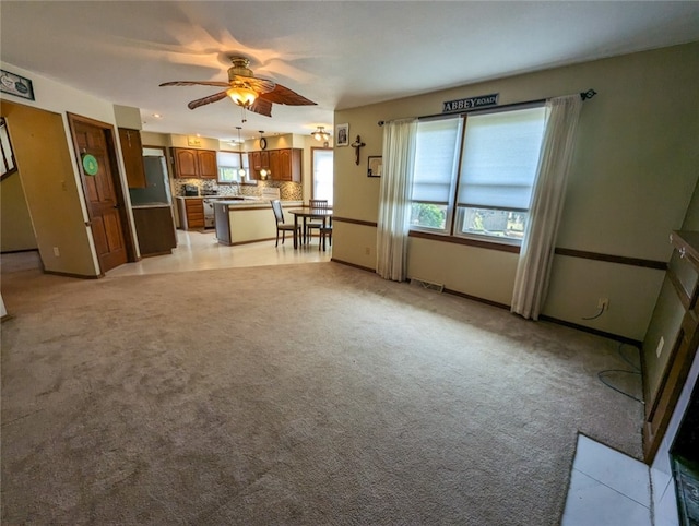 unfurnished living room with ceiling fan and light colored carpet