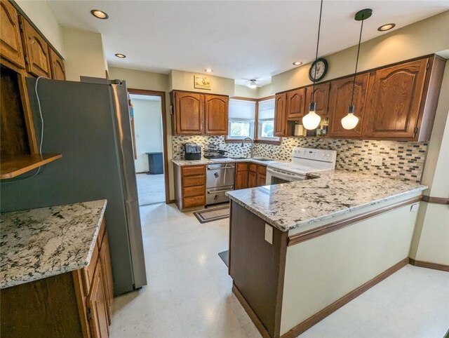 kitchen featuring light stone countertops, kitchen peninsula, stainless steel appliances, pendant lighting, and backsplash