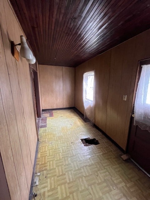 spare room with wooden walls and light parquet flooring