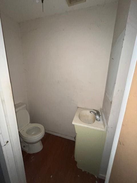 bathroom with vanity, toilet, and hardwood / wood-style floors