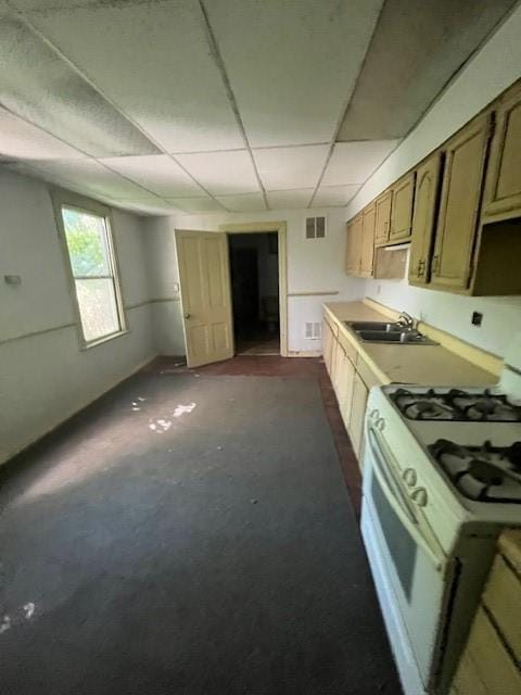 kitchen featuring a drop ceiling, sink, and white gas range oven