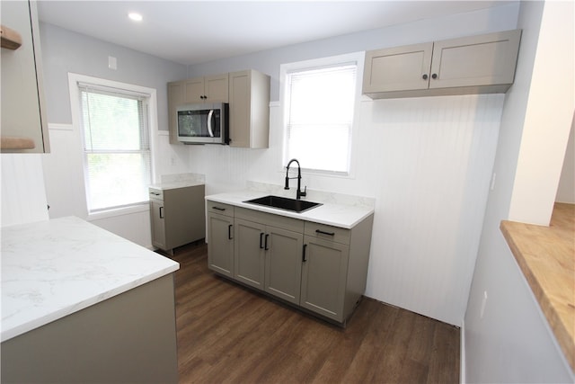 kitchen featuring dark hardwood / wood-style floors, sink, gray cabinets, and light stone counters