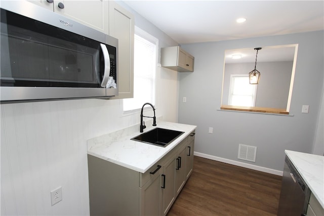 kitchen featuring light stone counters, sink, plenty of natural light, and dark hardwood / wood-style floors