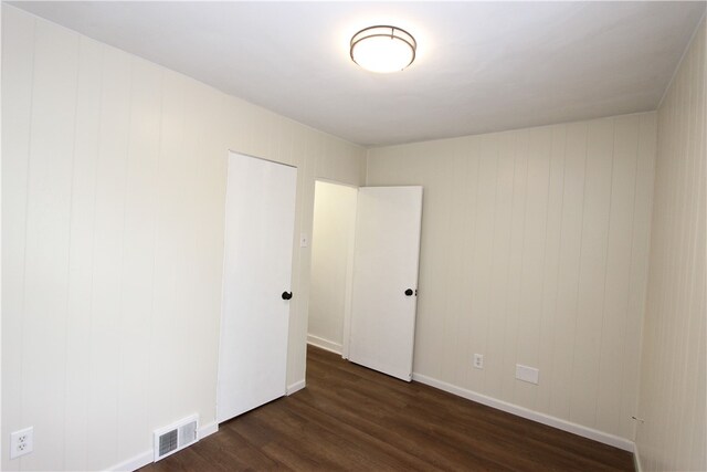 unfurnished bedroom with dark wood-type flooring