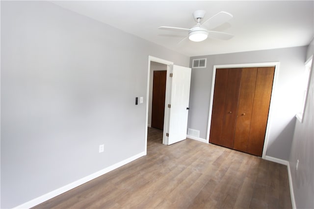 unfurnished bedroom with hardwood / wood-style flooring, a closet, and ceiling fan