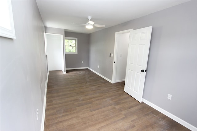 empty room with ceiling fan and dark wood-type flooring