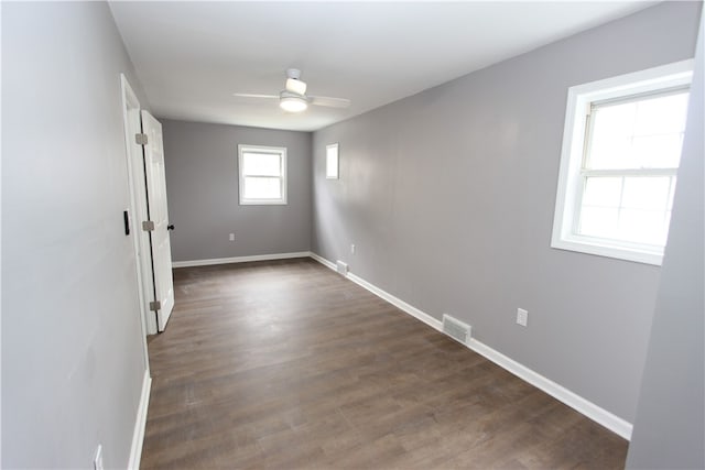 empty room with dark hardwood / wood-style floors and ceiling fan