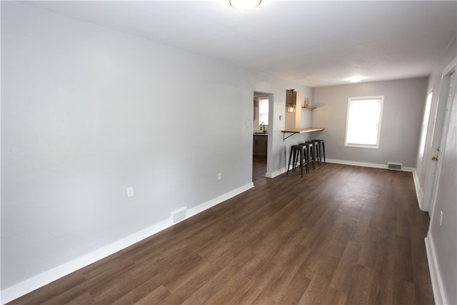 unfurnished living room with dark wood-type flooring