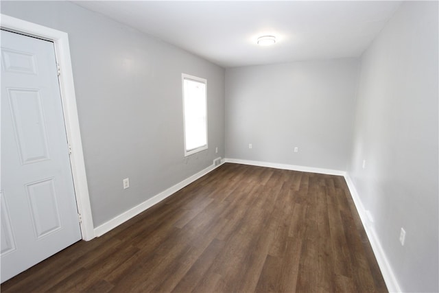 spare room with dark hardwood / wood-style flooring