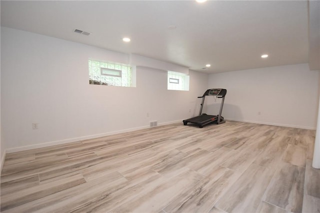 workout room featuring light wood-type flooring, visible vents, and baseboards