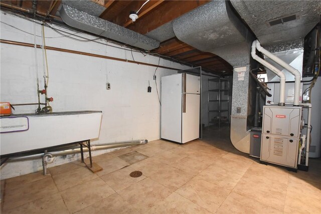 basement featuring white fridge and light tile flooring