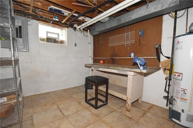 basement featuring tile floors, a workshop area, and water heater