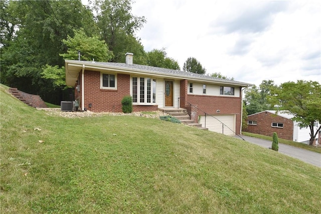 ranch-style home featuring brick siding, a chimney, an attached garage, a front yard, and driveway