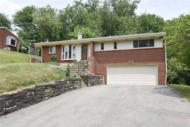 single story home with a garage, brick siding, driveway, and a front lawn