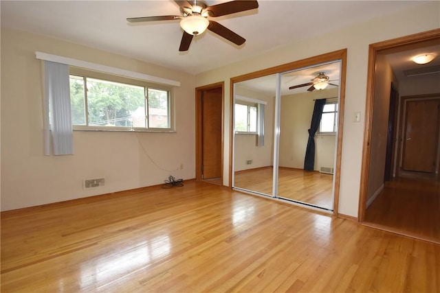 unfurnished bedroom with visible vents, light wood-style flooring, and a ceiling fan