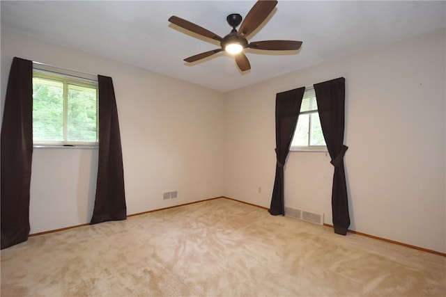 carpeted spare room featuring ceiling fan