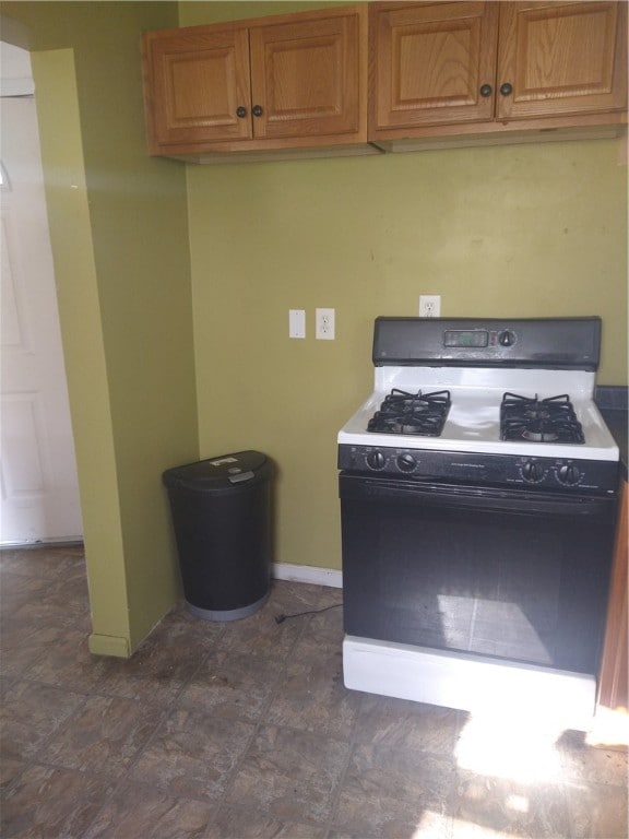 kitchen featuring dark tile flooring and white range with gas cooktop