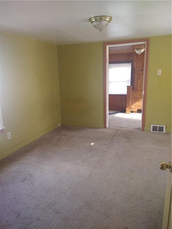 empty room with visible vents, baseboards, and carpet flooring