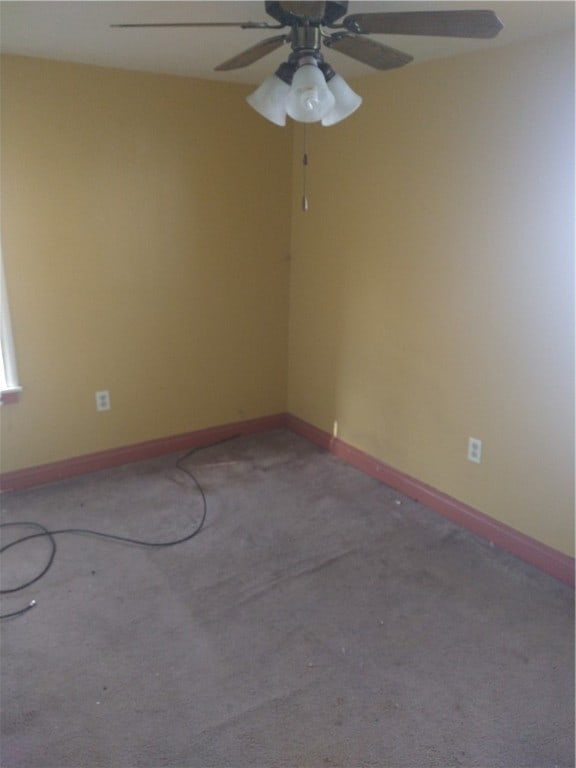 carpeted spare room featuring ceiling fan